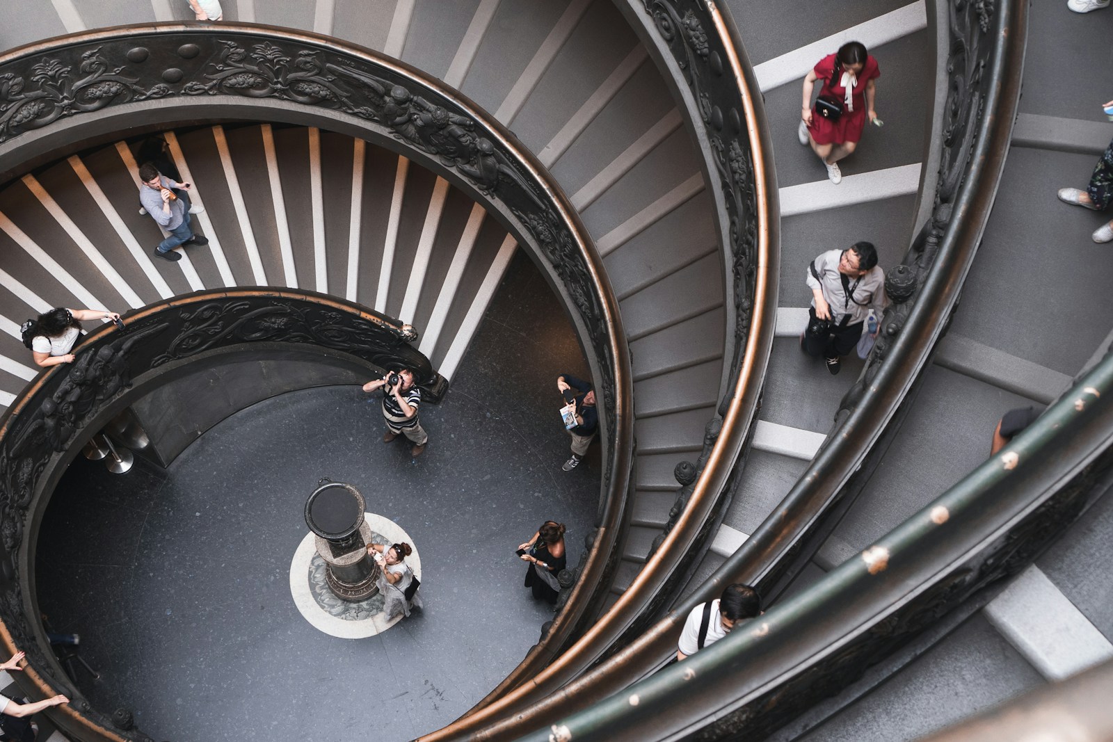 people walking on spiral stairs inside building