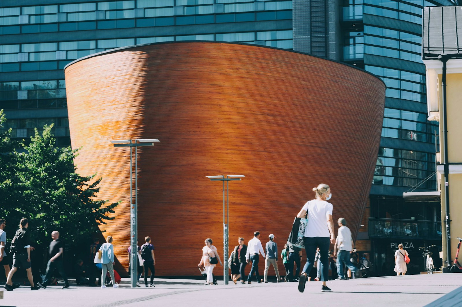 a group of people walking down a street next to a tall building