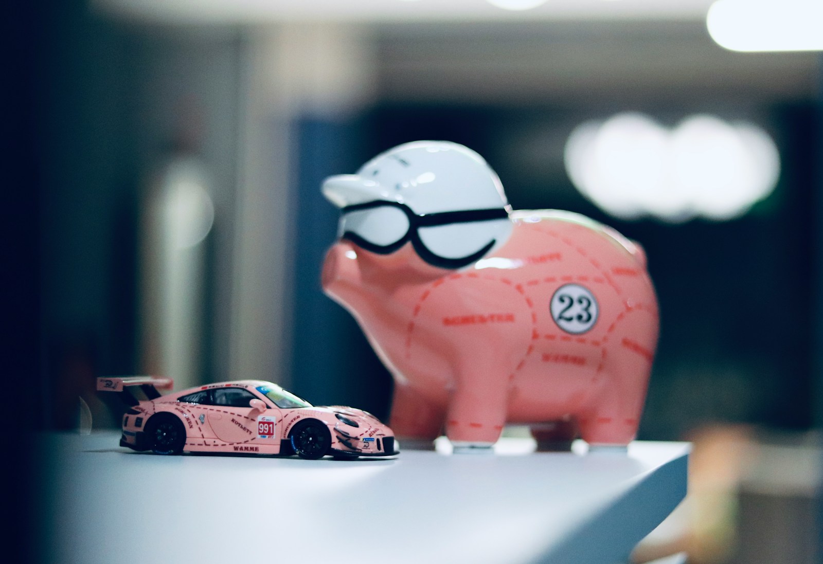 a pink piggy bank sitting on top of a table next to a pink car