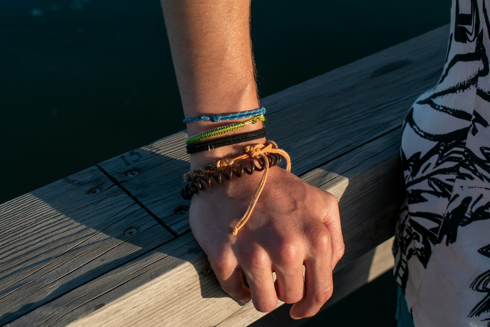 a person with a bracelet on their hand on a dock