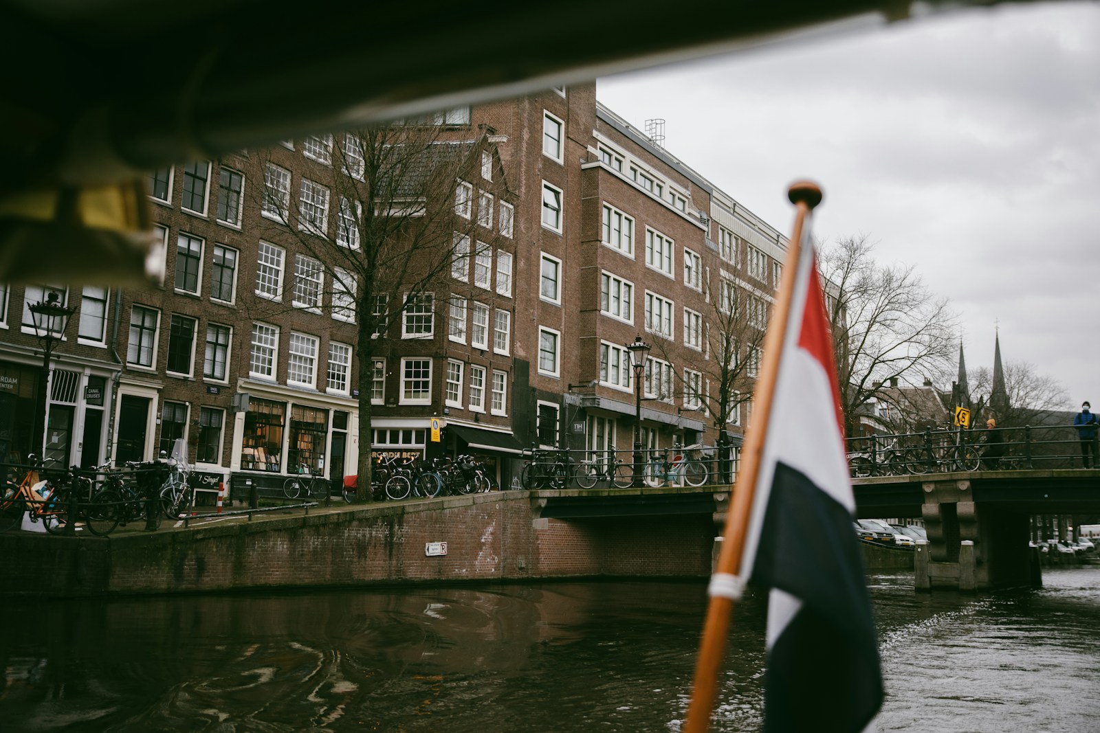 a flag on a pole next to a body of water