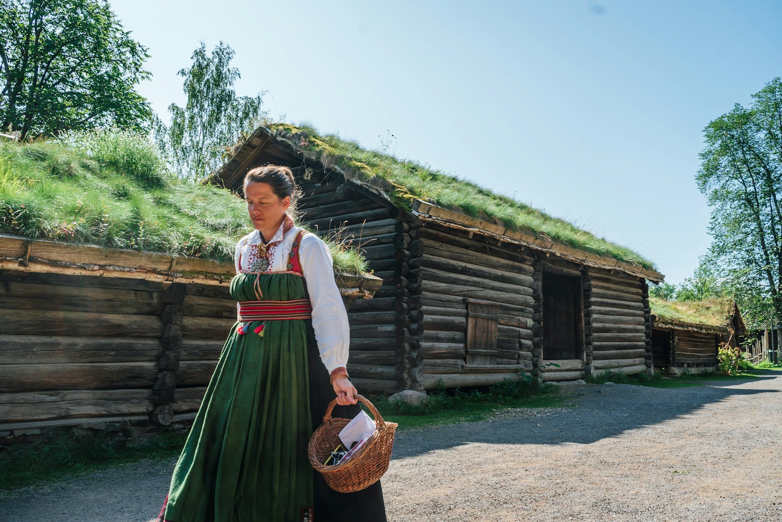 a woman in a green dress holding a basket