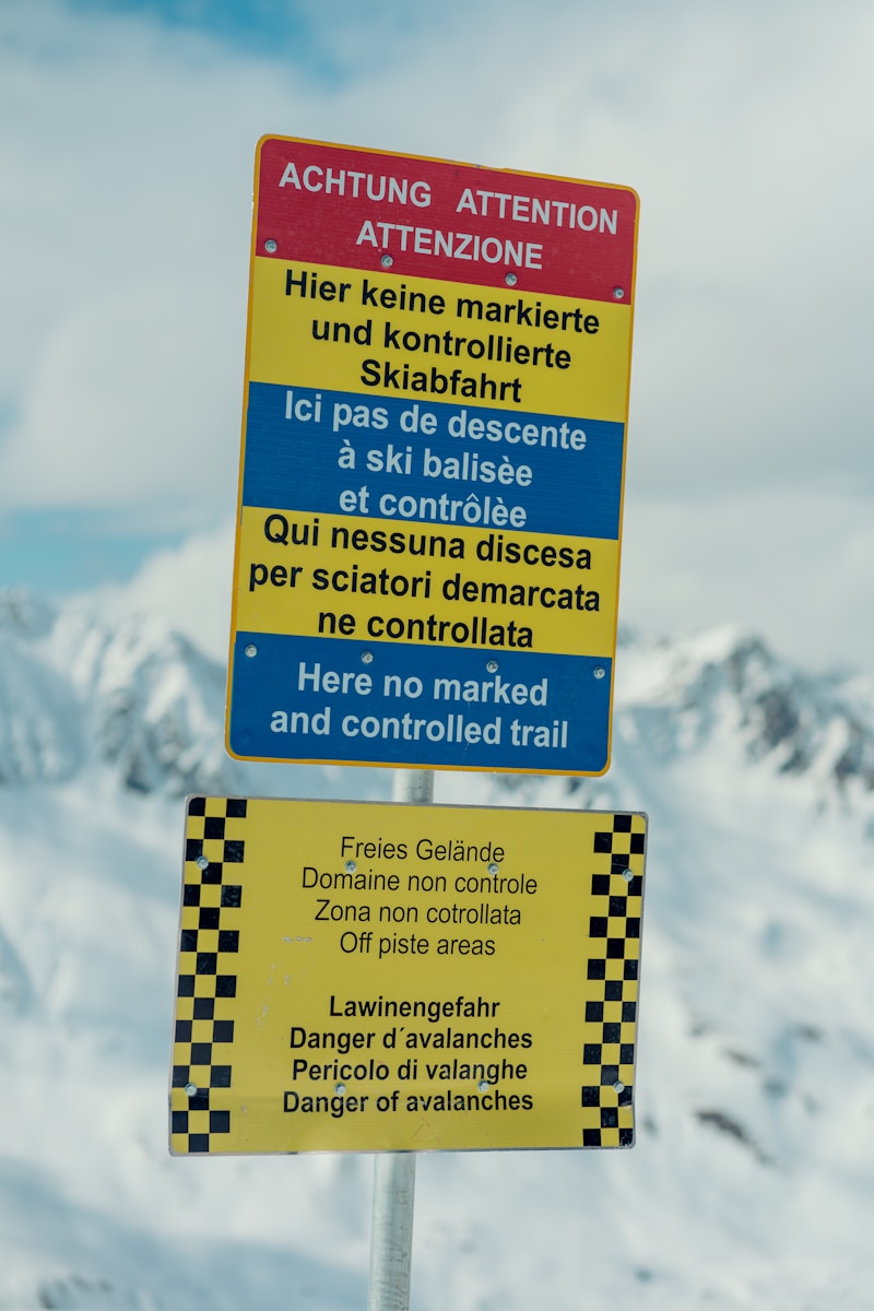 a yellow and blue sign sitting on top of a snow covered mountain