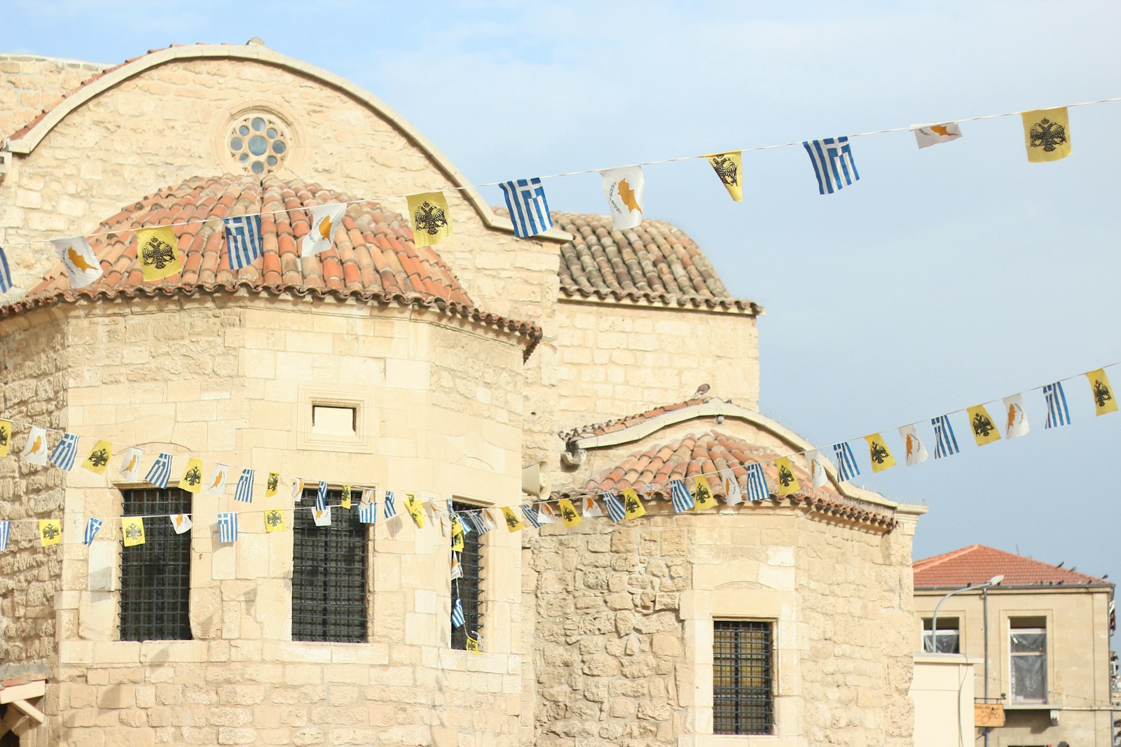 a building with a lot of flags hanging from it's roof